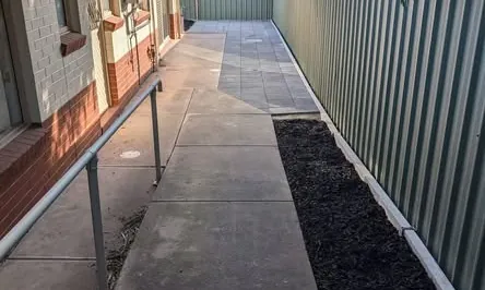 Side yard with new paving and a mulched garden bed